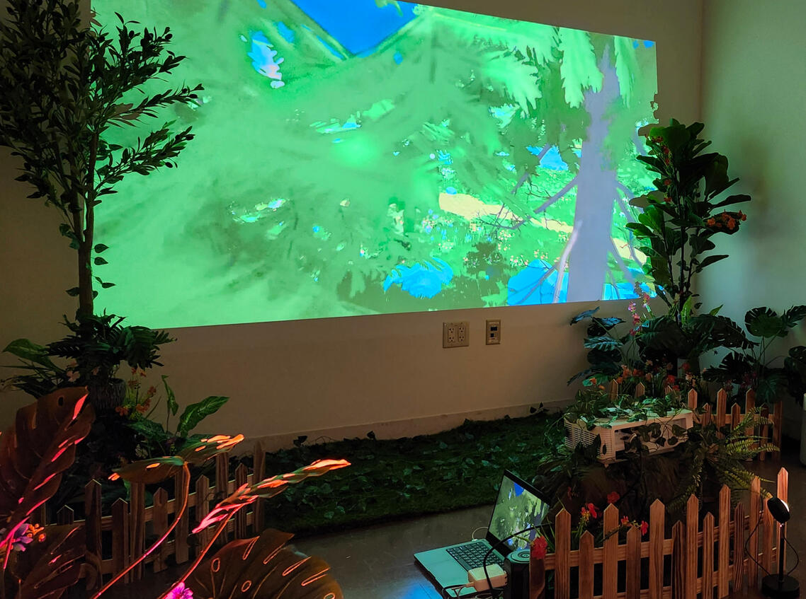 View of the garden with the projector setup - the laptop is plugged into the projector elevated on top of a mound.